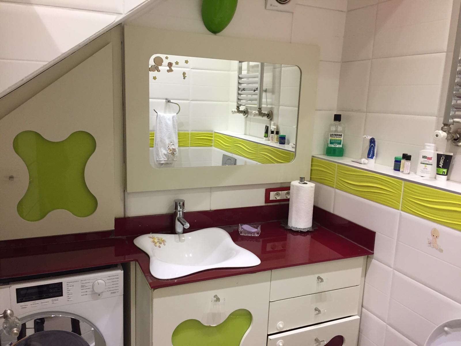 Bespoke corner vanity engineered around a sloped ceiling with integrated laundry.