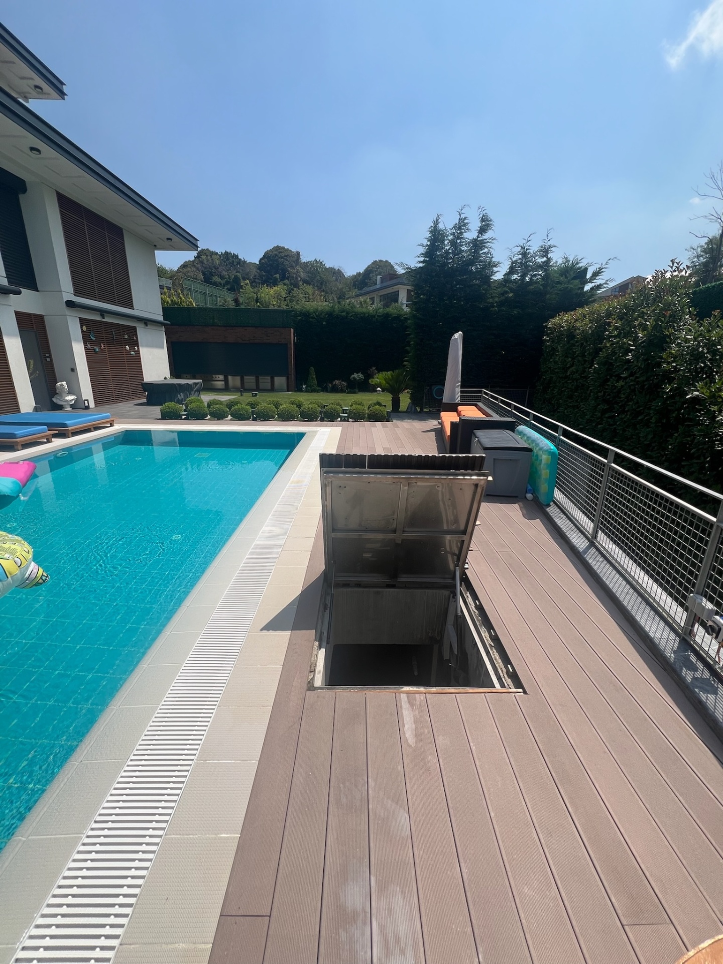 Pool-side technical access — flush stainless hatch integrated into deck.