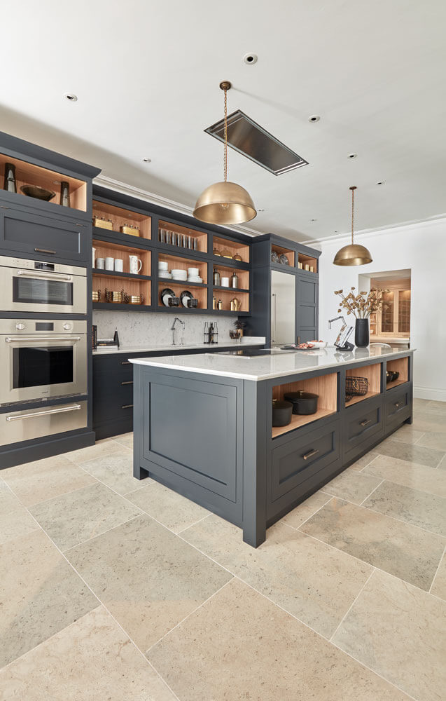 Charcoal shaker island with open oak plate racks and brass dome pendants