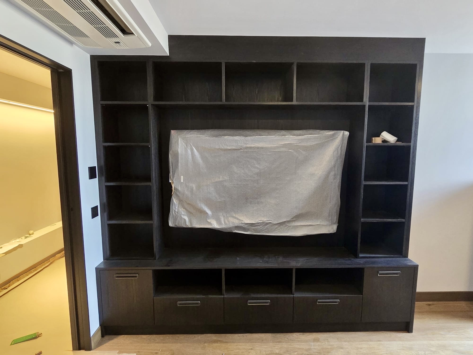 Ebonised oak library-style media wall with symmetrical open shelving