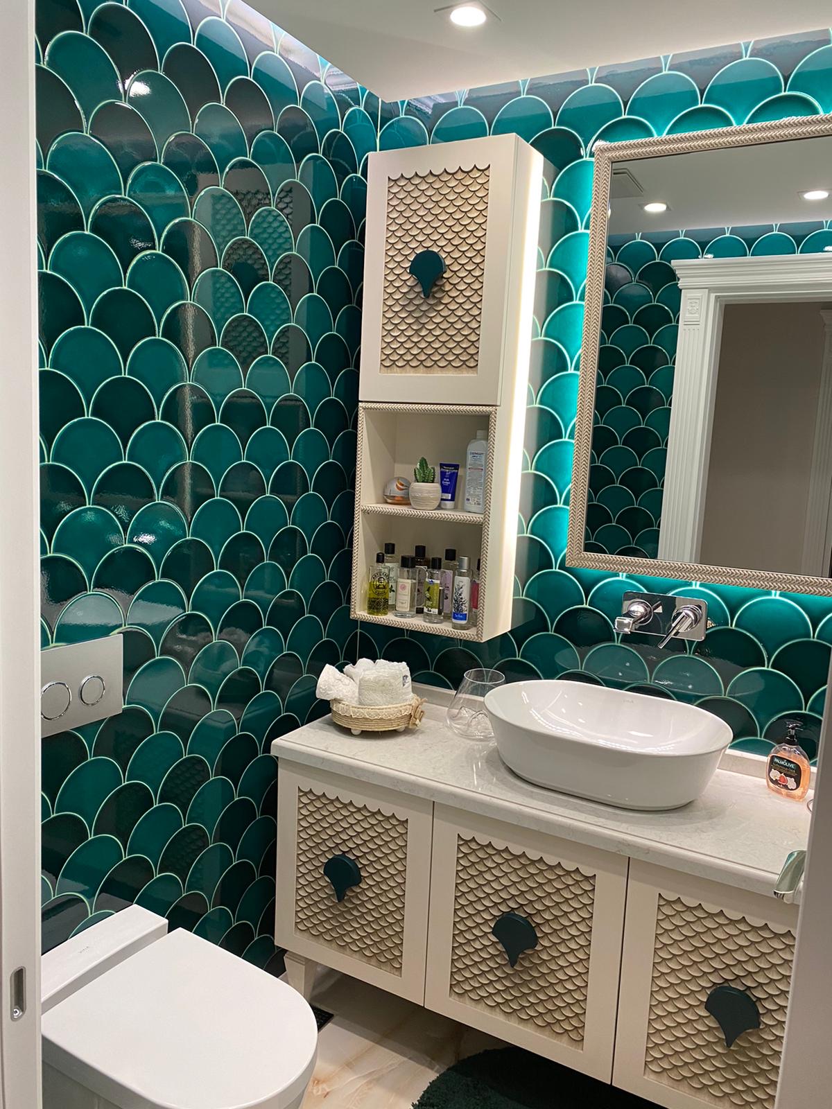 Fish-scale mosaic ensuite with matching scale-carved joinery and integrated LED shelving.