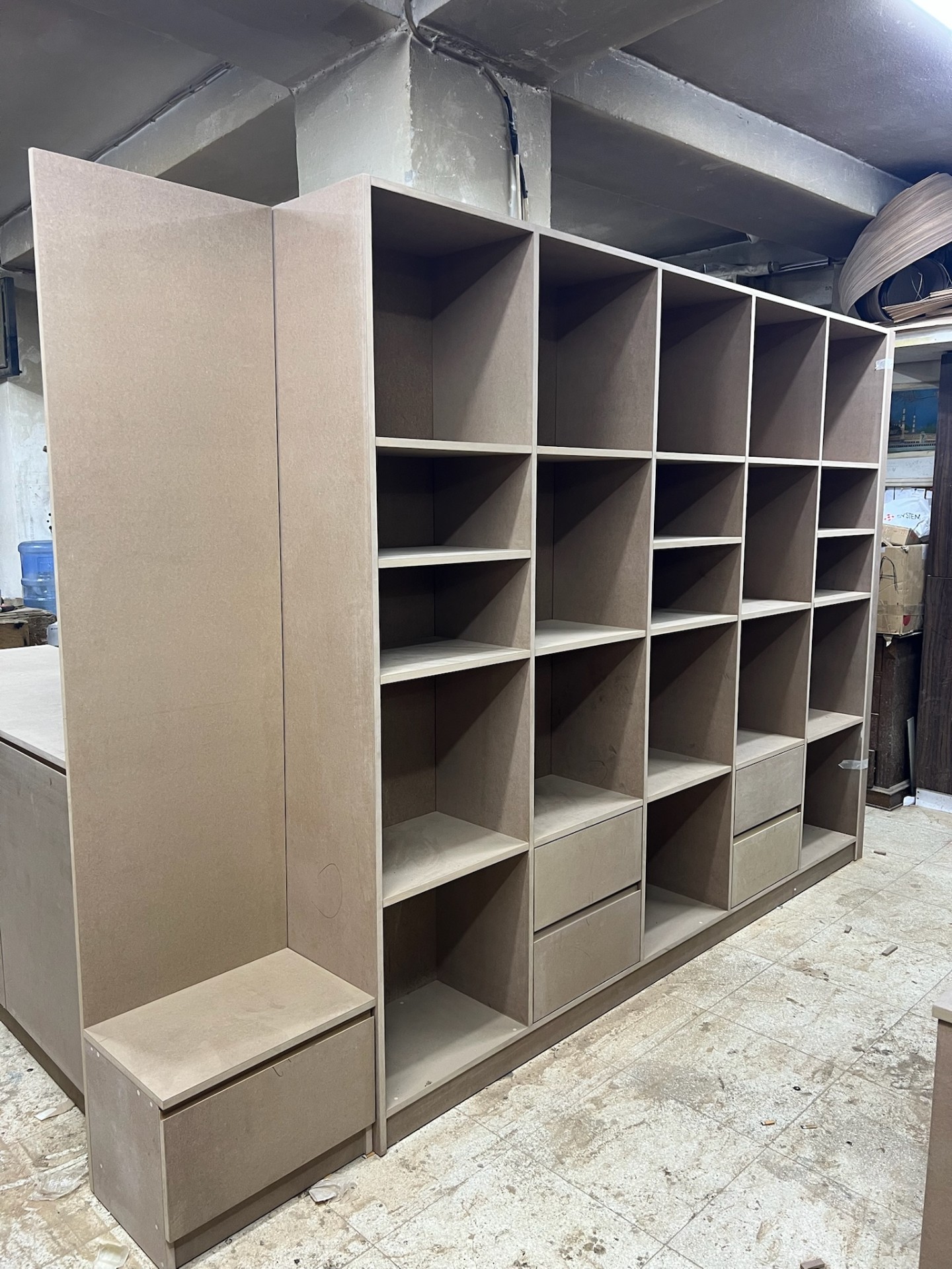Modular open shelving grid with integrated drawers — workshop assembly