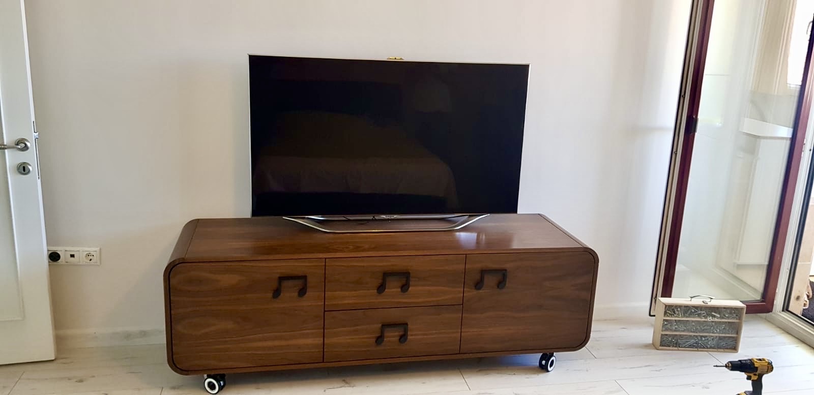 Curved walnut console with sculpted note-shaped pulls