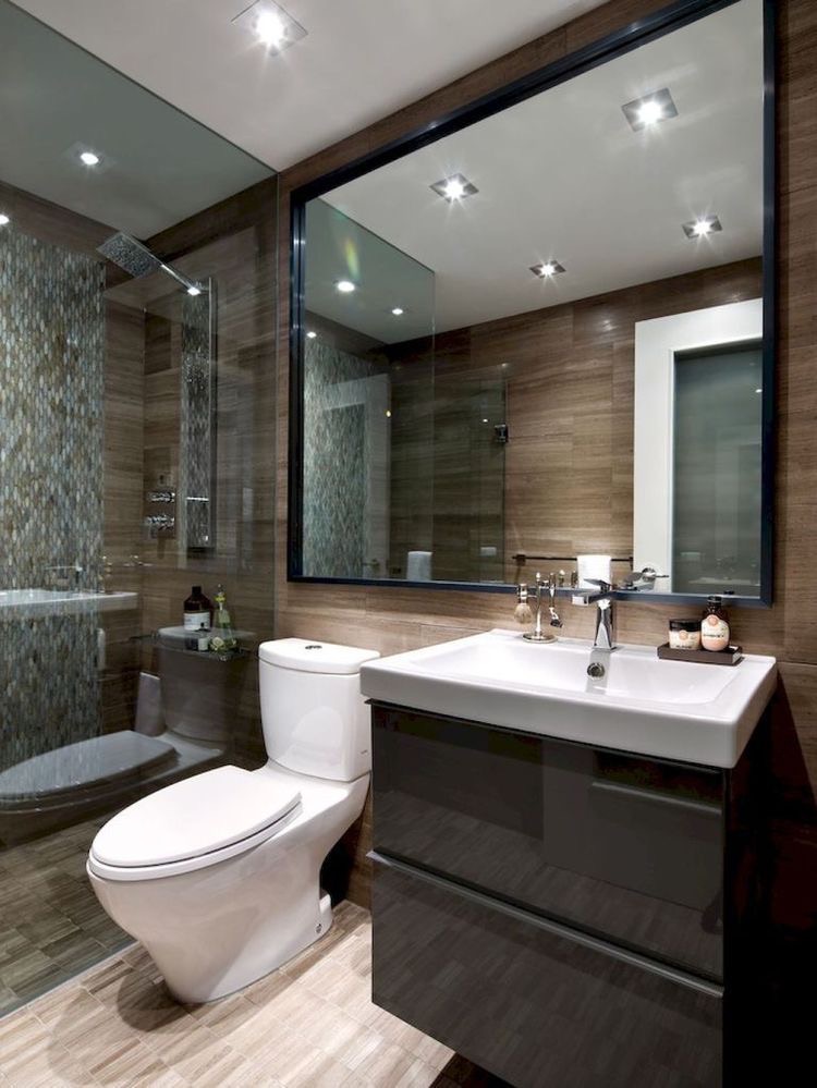 High-gloss graphite vanity against walnut-effect stone with framed mirror gallery.
