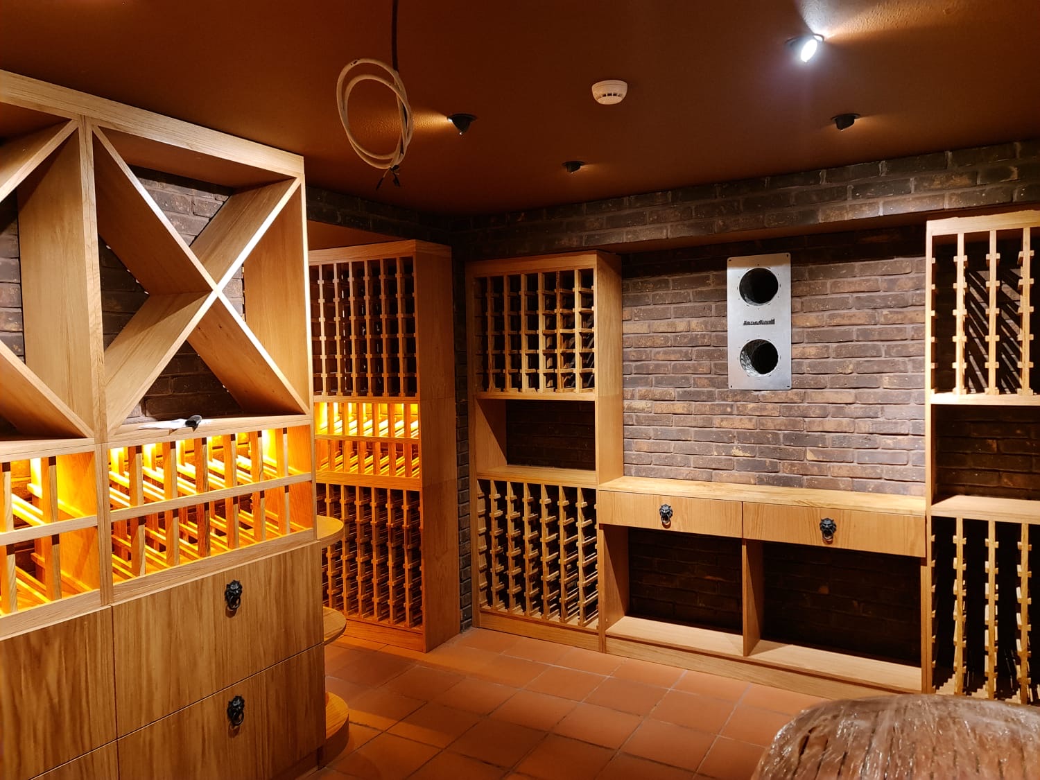 Full cellar composition — brick, oak lattice, brass ambience.