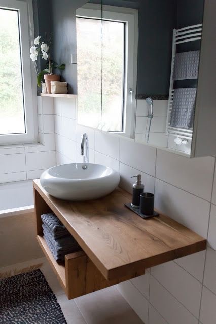Floating solid-oak console with open shelf and countertop vessel basin.