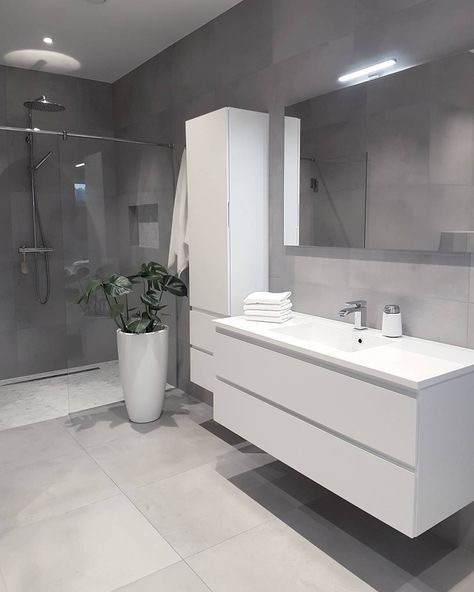 Handleless floating vanity and tall tower unit in matt white on soft grey stone.