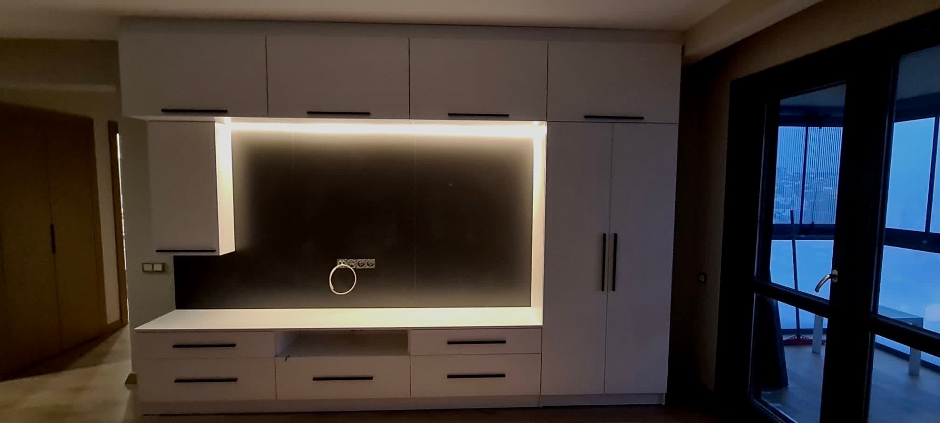 Full-wall storage system with integrated backlit TV niche