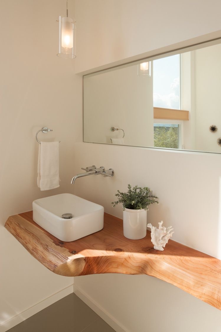 Live-edge timber slab vanity cantilevered from the wall with wall-mounted mixer.
