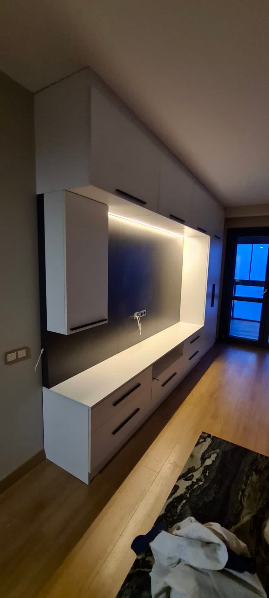 Floating white lacquer media unit with LED-lit dark inlay