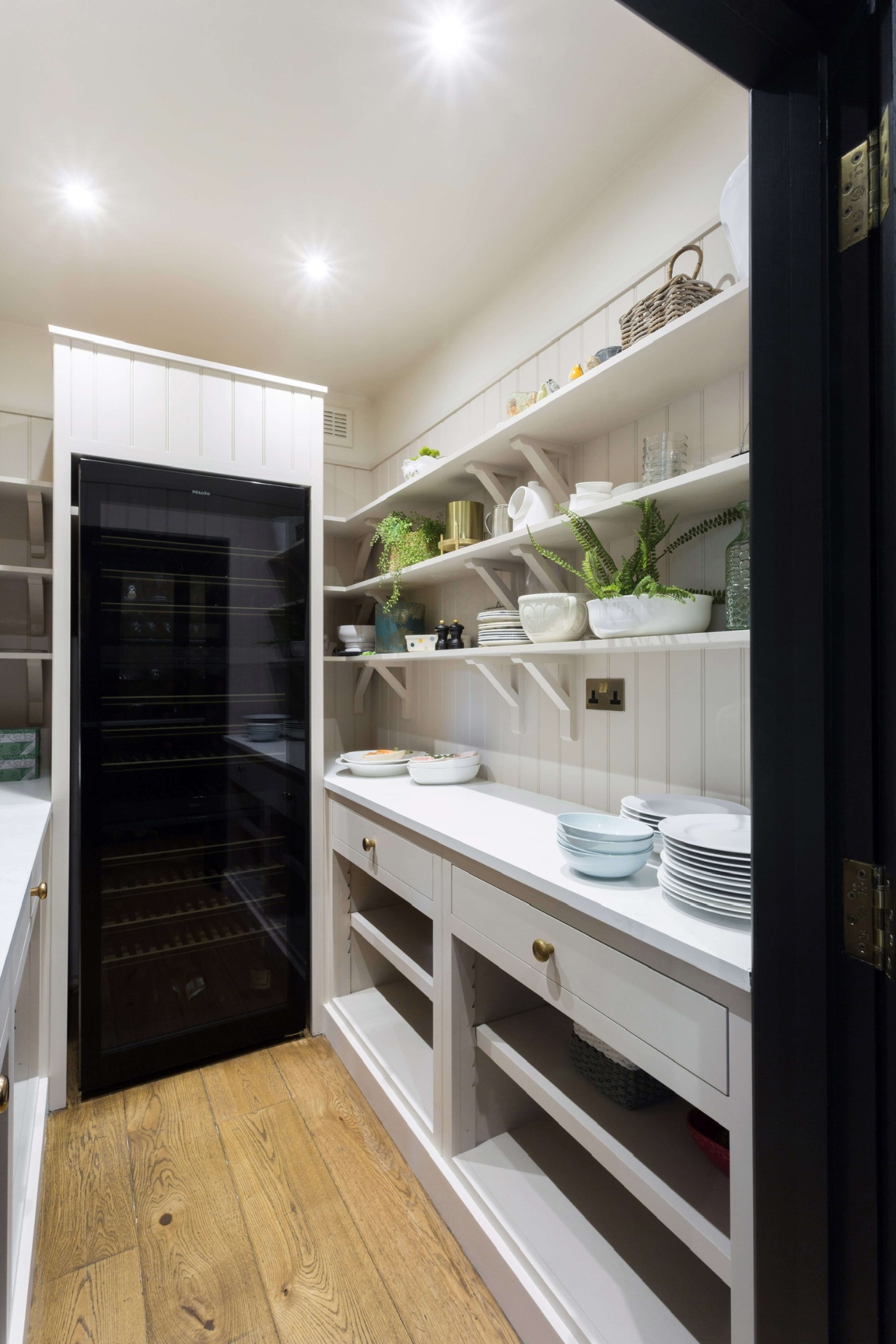 Adjoining butler's pantry with open plate shelving and wine tower
