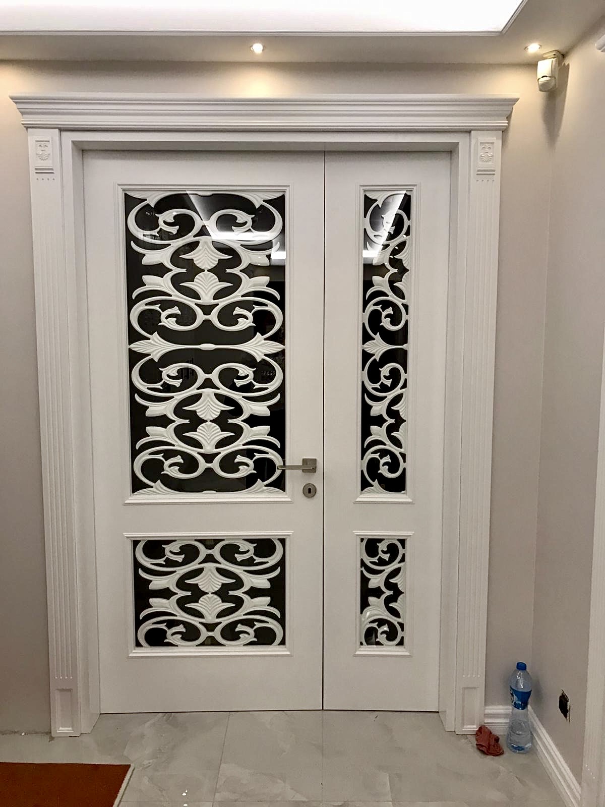 Classical double door with hand-carved scrollwork fretwork and pilaster casing