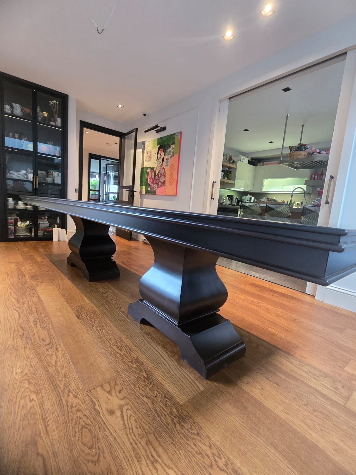 Extended ebonised dining table on twin baluster pedestals