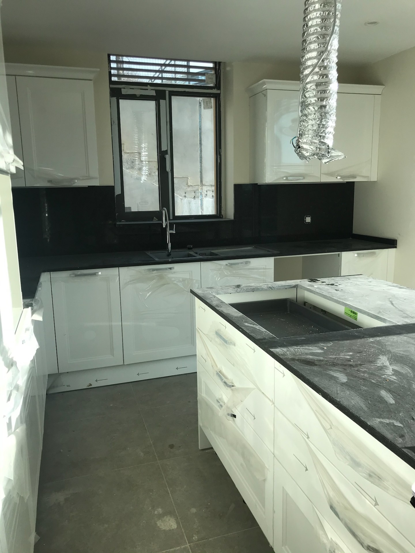 High-gloss classical kitchen with absolute black granite — install stage
