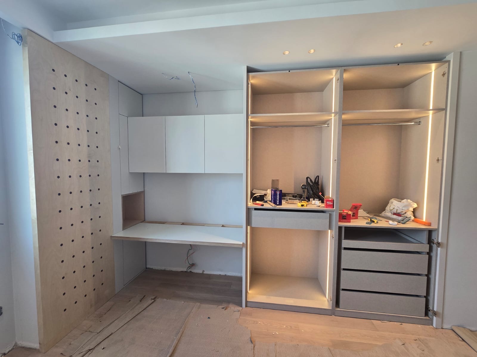 Study-integrated wardrobe with pegboard and LED-lit interiors