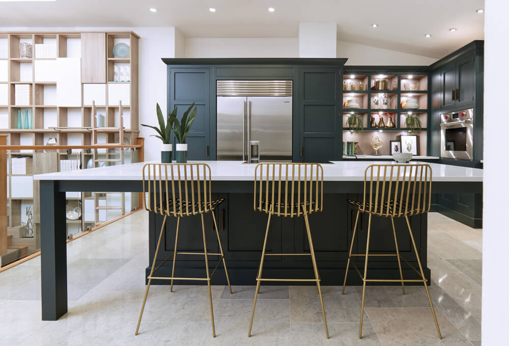 Dual-tone kitchen — forest green island paired with oak library shelving
