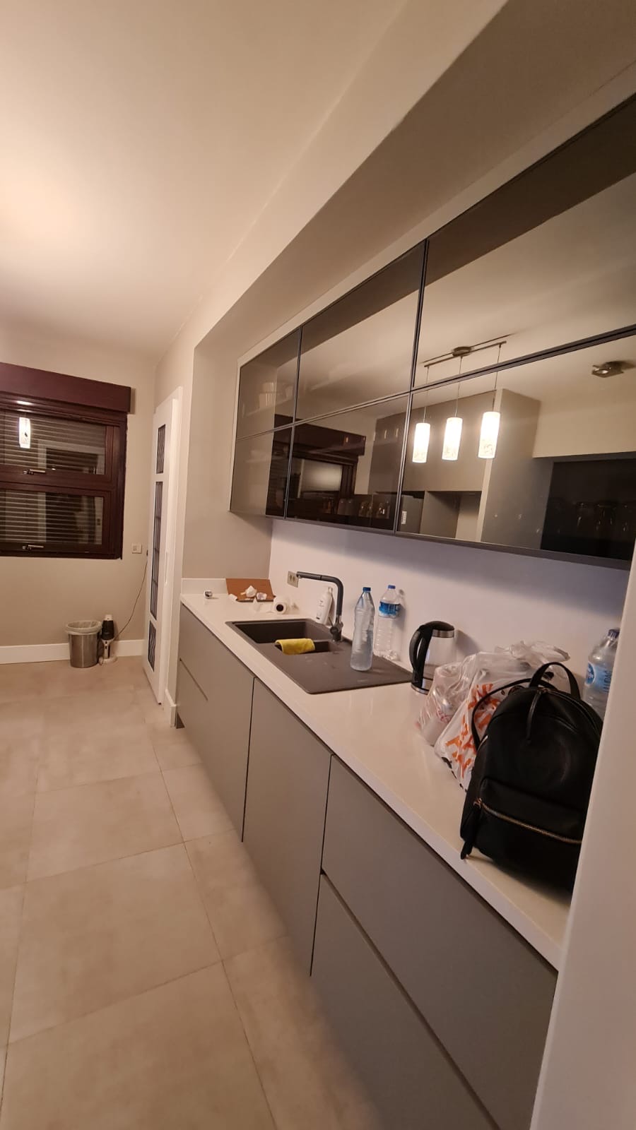 Compact galley kitchen with smoked glass upper cabinetry